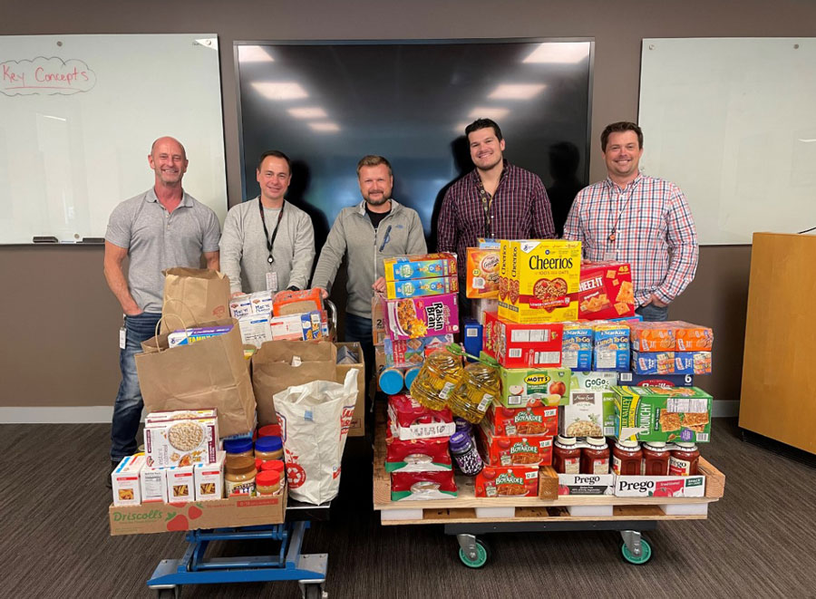 onsemi employees standing by a pile of food they collected to help others.
